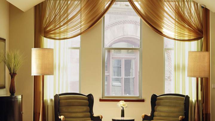 Two Brown Chairs Side Lamps in Room